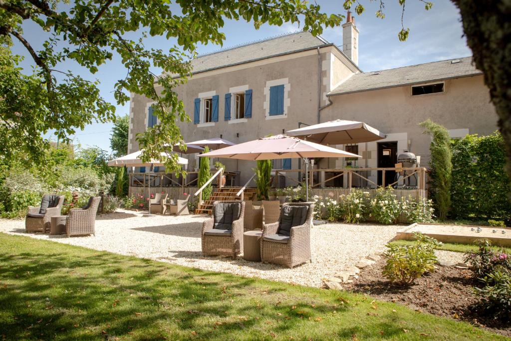 a group of chairs and umbrellas in front of a house at Chambres d’hôtes La Joyeuse in Préveranges