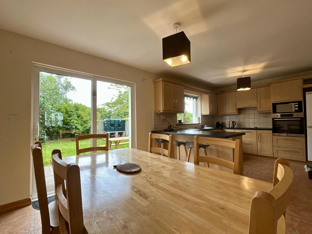 a kitchen with a wooden table and a large window at An Tulan Cleasach Spiddal in Spiddal