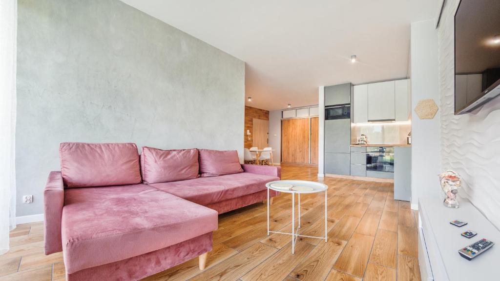 a living room with a pink couch and a table at Jantar Park in Jantar