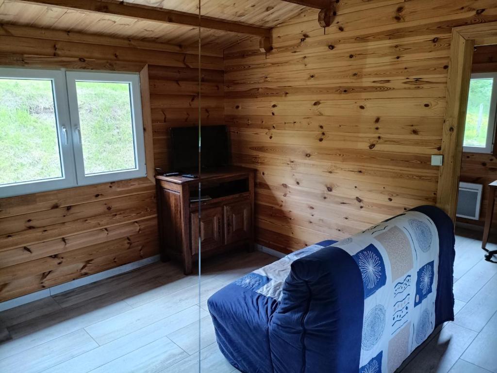 a living room with a couch in a log cabin at Le chalet d'Empeytepas in Céaux-dʼAllègre