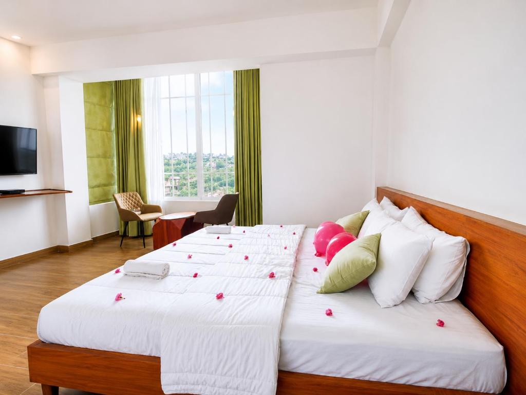 a hotel room with two beds and a television at New Pensive Villa in Nuwara Eliya