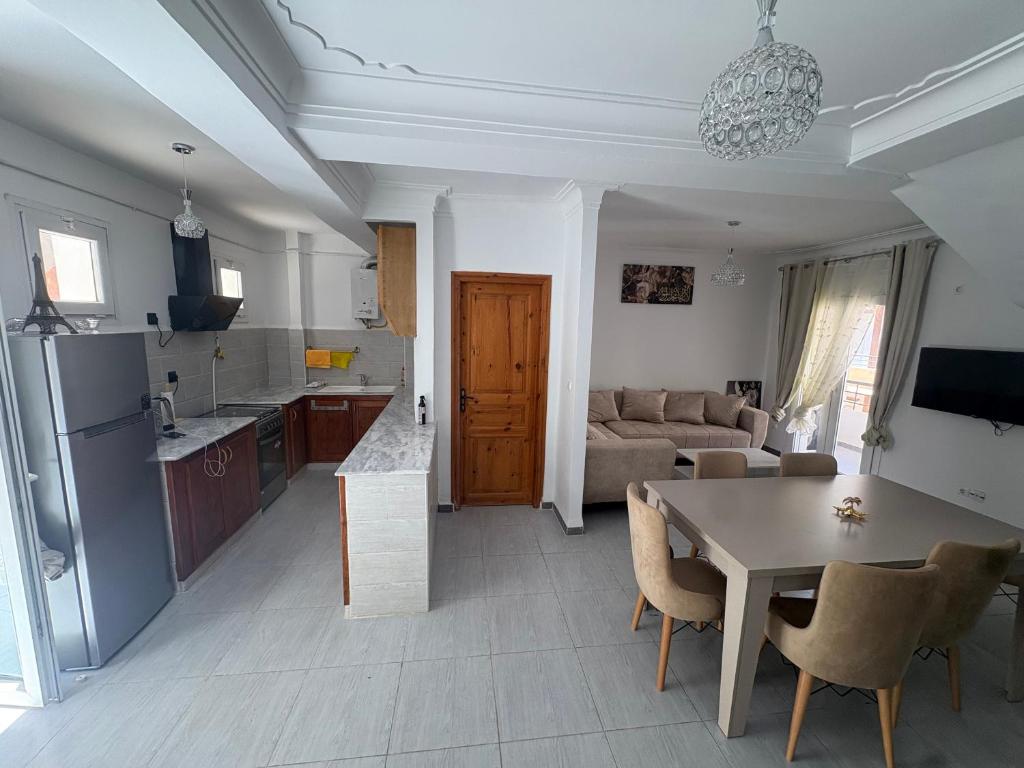 a kitchen and living room with a table and a couch at Talia in Bejaïa