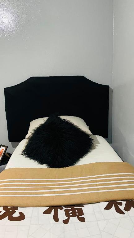 a black furry pillow on top of a bed at 52Golfcourseview guest house in Pimville