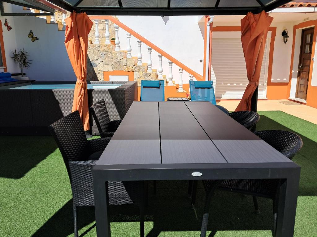 a table with chairs and an umbrella on a patio at Moradia perto dos Palmares in Lagos