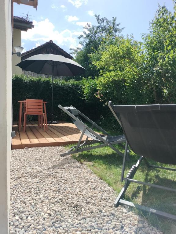 a patio with a chair and an umbrella and a table at Le Bâti in Servoz