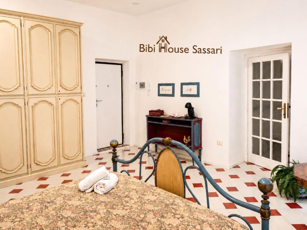 a kitchen with a table and a sign that reads bus house sash at Bibi House in Sassari