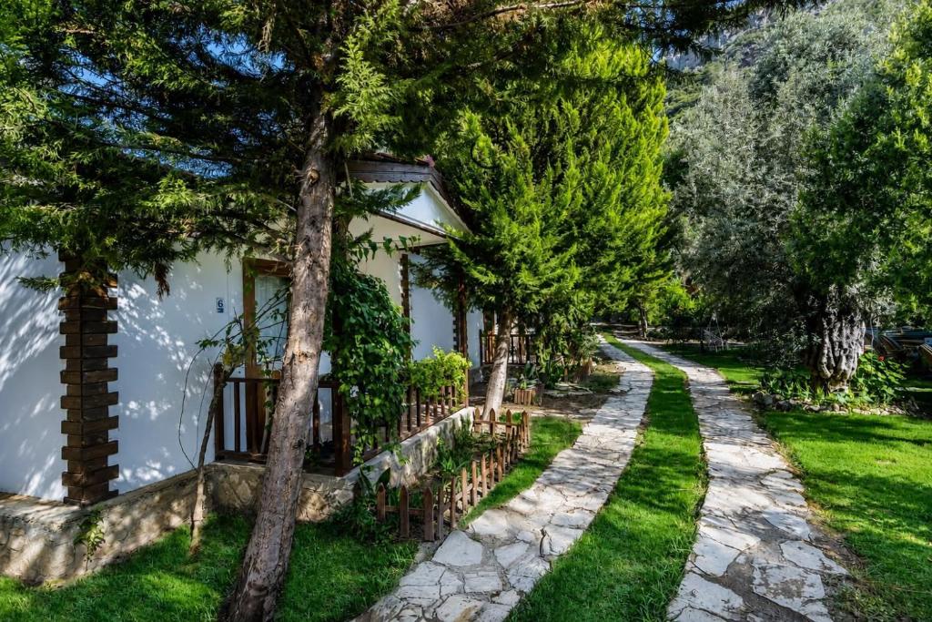 a house with a walkway next to a yard at Petrinos Butik Otel in Datca