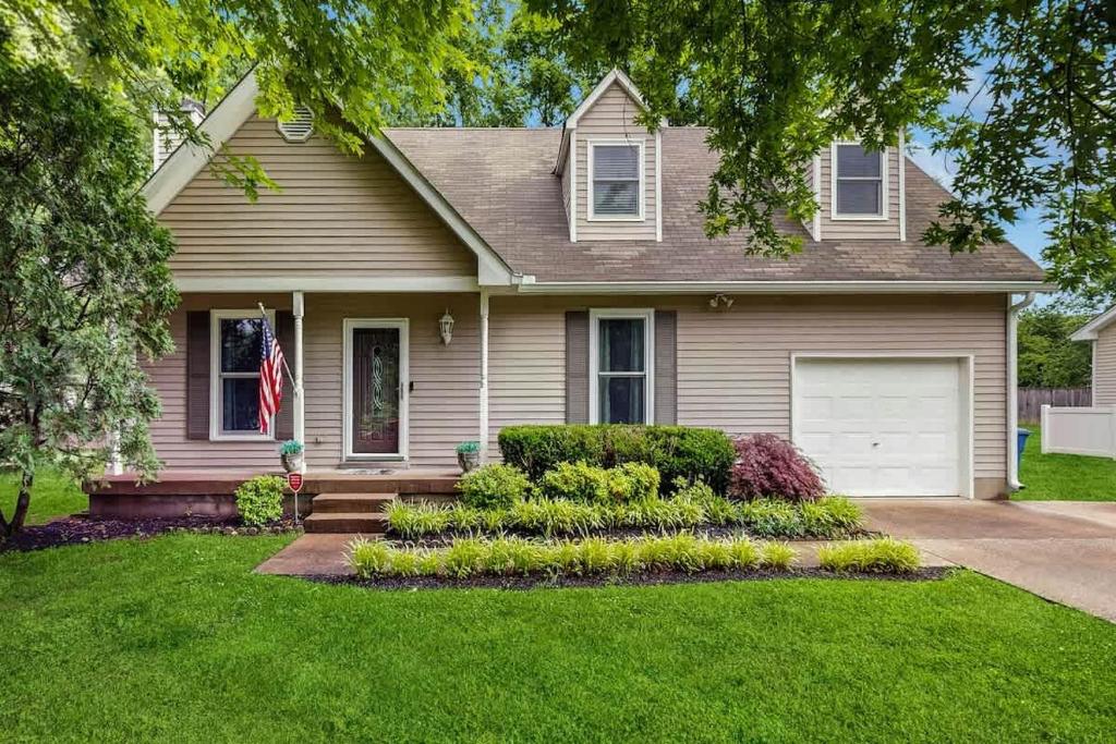 a house with a grass yard with a driveway at Rustic Retreat in Franklin
