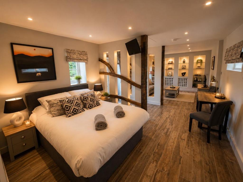 a bedroom with a large bed and a dining room at The Stalls Suite at Strattons in Swaffham