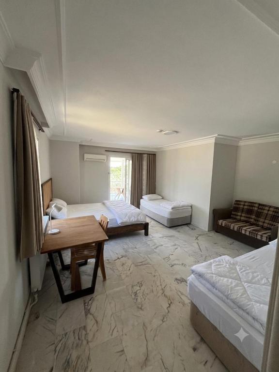a hotel room with two beds and a table at Narçiçeği in Değirmendere