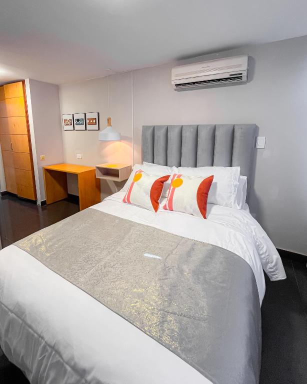 a bedroom with a large white bed with two pillows at Hotel Centro in Cali
