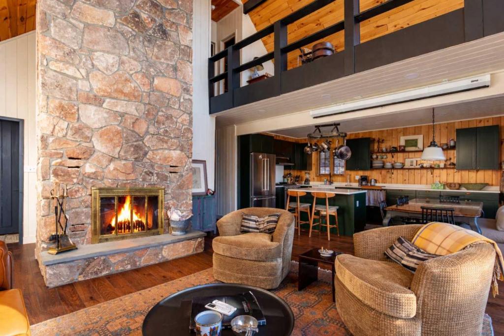 a living room with a large stone fireplace at The Bellows House - Views Deck Skiing in Fleischmanns