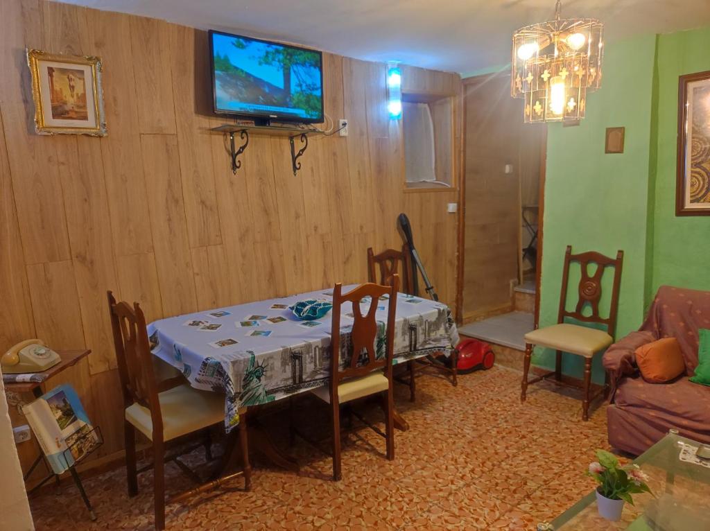 a living room with a table and a tv on the wall at Casa Solana in Cambil