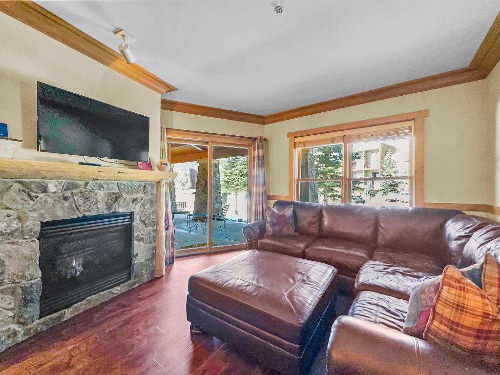 a living room with a leather couch and a fireplace at CS129 Copper Springs in Copper Mountain