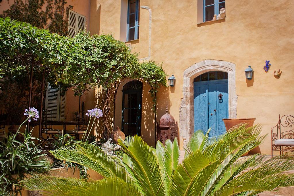 a house with a blue door and some plants at Maison Saint Louis avec Jacuzzi in Besse-sur-Issole