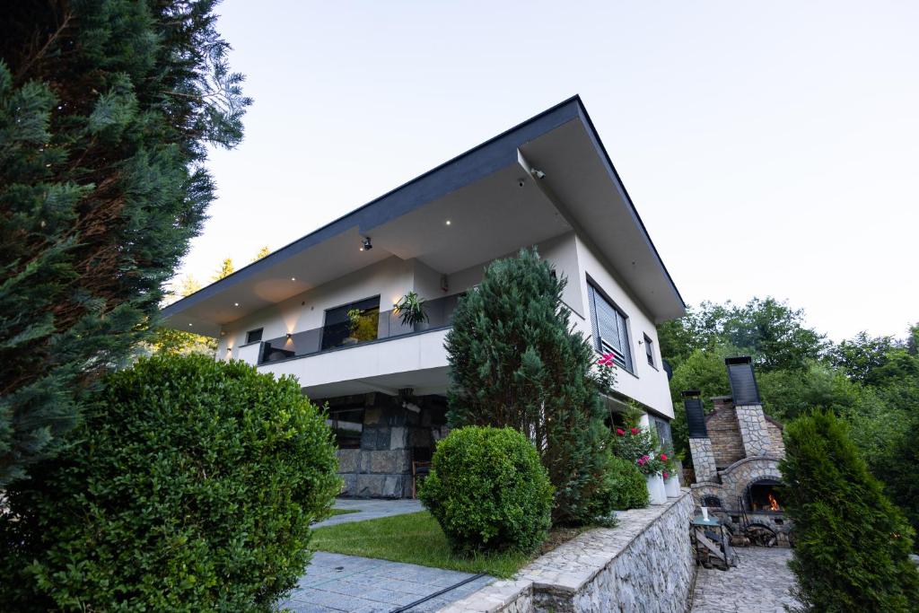 a white house with a black roof at Villa Eterna in Tarčin