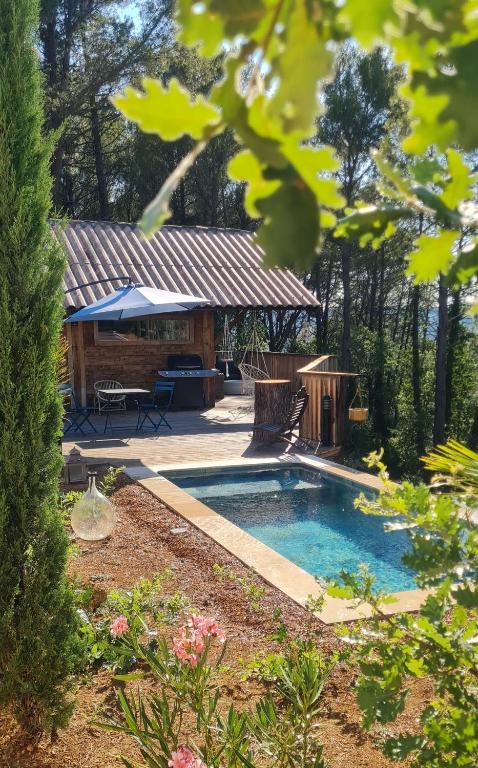 a swimming pool in a yard with a house at Le Masdemoiselle Chalet in Salernes