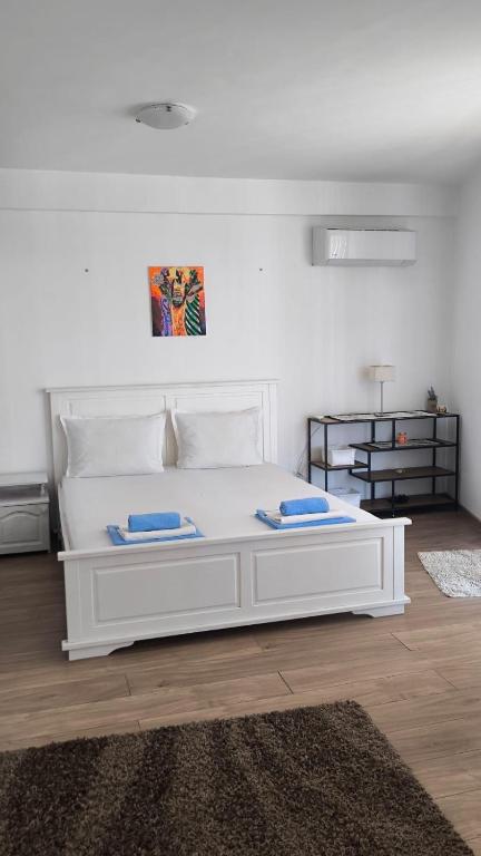 a white bed with two pillows on it in a room at Студио JASMIN in Tsarevo