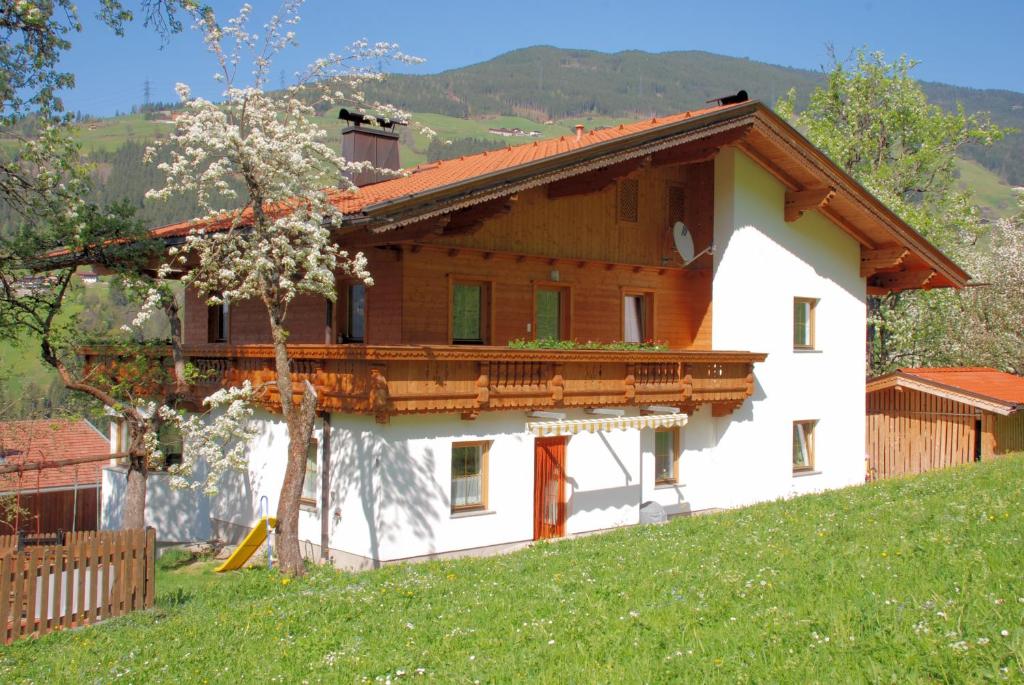 uma casa branca com uma varanda numa colina em Blaserhof Hainzenberg em Hainzenberg