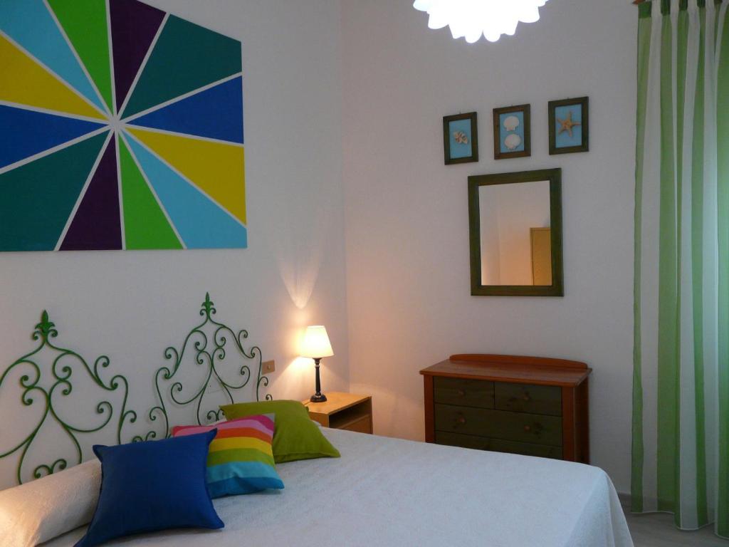 カスティリオーネ・デッラ・ペスカーイアにあるAppartamento Tinoのベッドルーム1室(ベッド1台付)が備わります。壁には絵画が飾られています。
