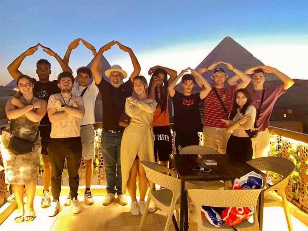 a group of people posing for a picture in front of the pyramids at Comfort Pyramids Inn in Cairo