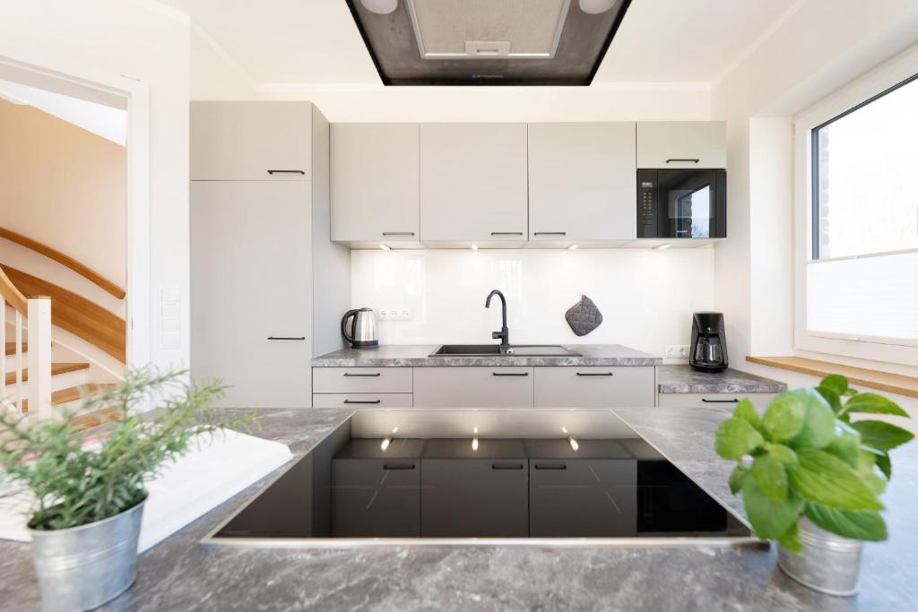 a kitchen with white cabinets and a sink at Reiterhof Rickert Glücksklee in Meeschendorf