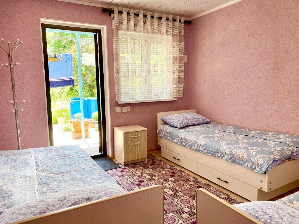 a bedroom with two beds and a door to a patio at Alaman Guest House in Kaji-Say
