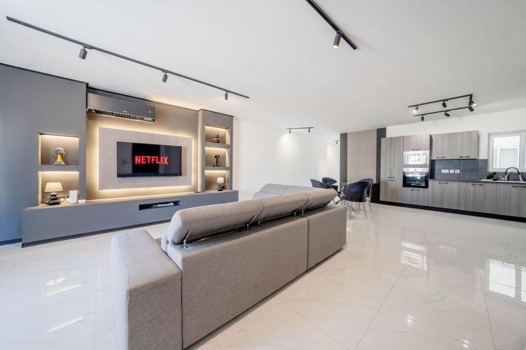 a living room with a couch and a flat screen tv at Sandy Soul in Birżebbuġa