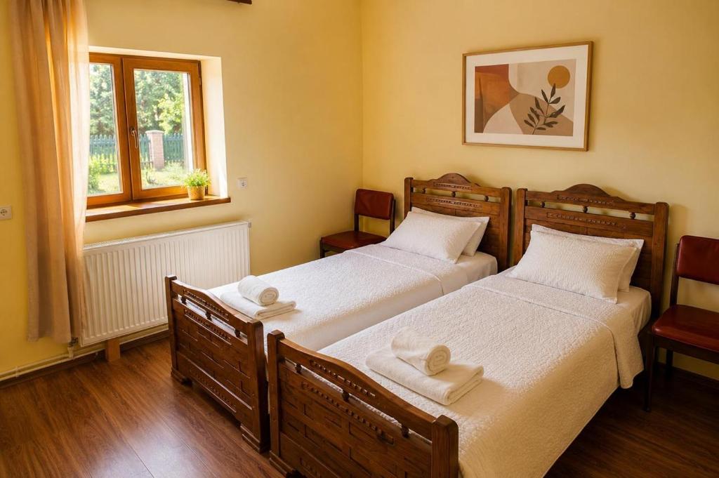 two beds in a room with two windows at Teo Guesthouse and Camping in Mestia in Mestia