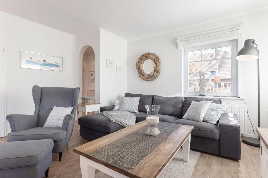 a living room with a couch and two chairs and a table at Buhne 3 in Grömitz