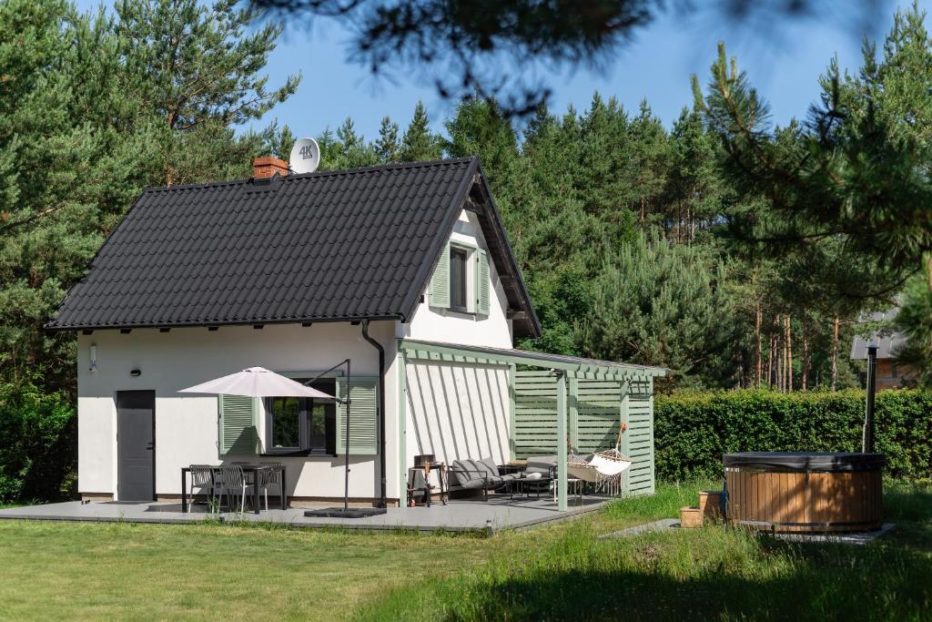 a cottage with a deck and a patio at LAS i MORZE in Czarny Młyn