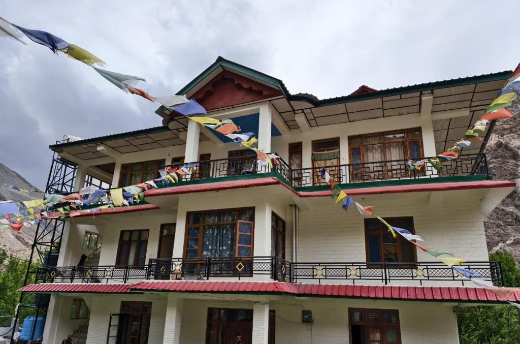a building with flags and flags in front of it at The Moonland Homestay in Shalkār