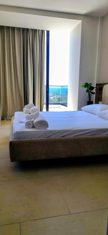 a large bed in a room with a large window at Emili Premium Residence in Qeparo