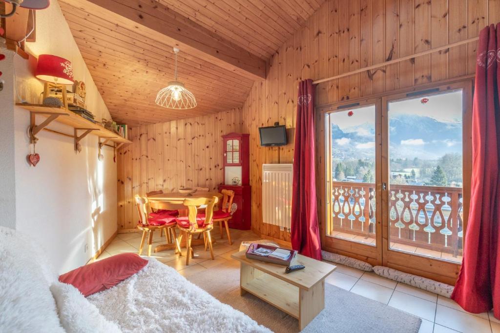 a room with a bed and a table and a balcony at 6 pers, proche pistes et commerces in Morillon