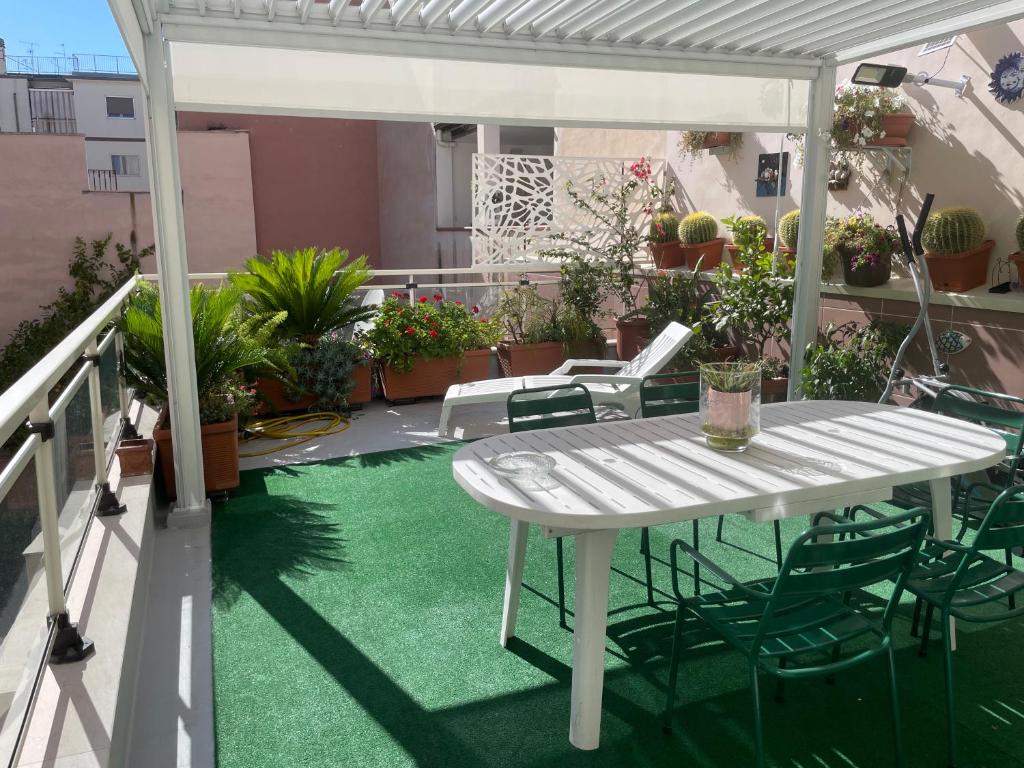 a white table and chairs on a balcony with green grass at B&B Imagine in Bari