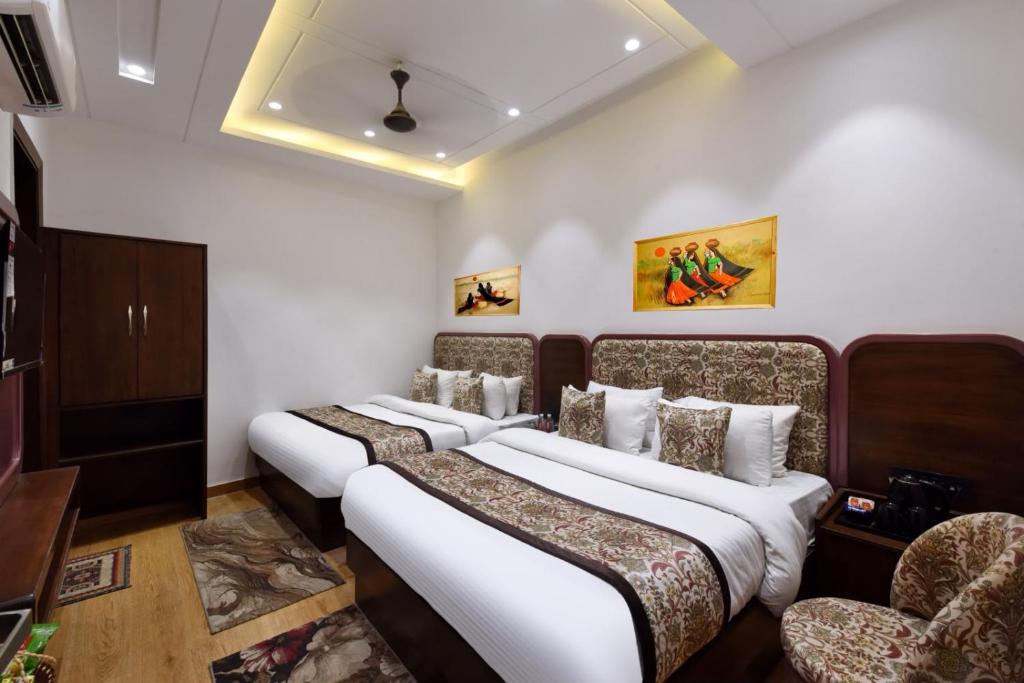 a hotel room with two beds and two chairs at Hotel Namaskar India - Just A Minute Away From New Delhi Railway Station & Connaught Place in New Delhi