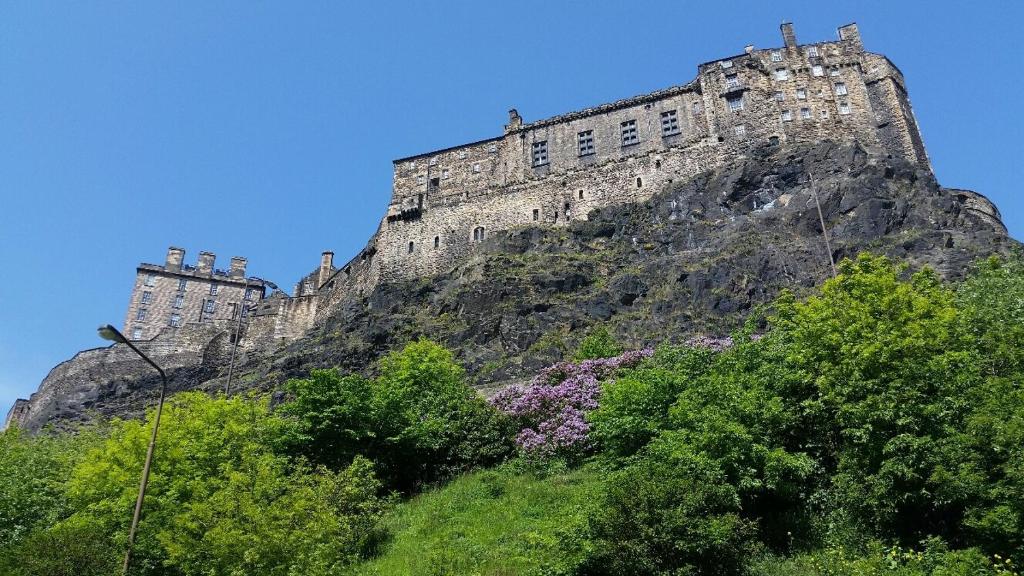 a castle on top of a mountain with trees at The Wee Thistle in Edinburgh