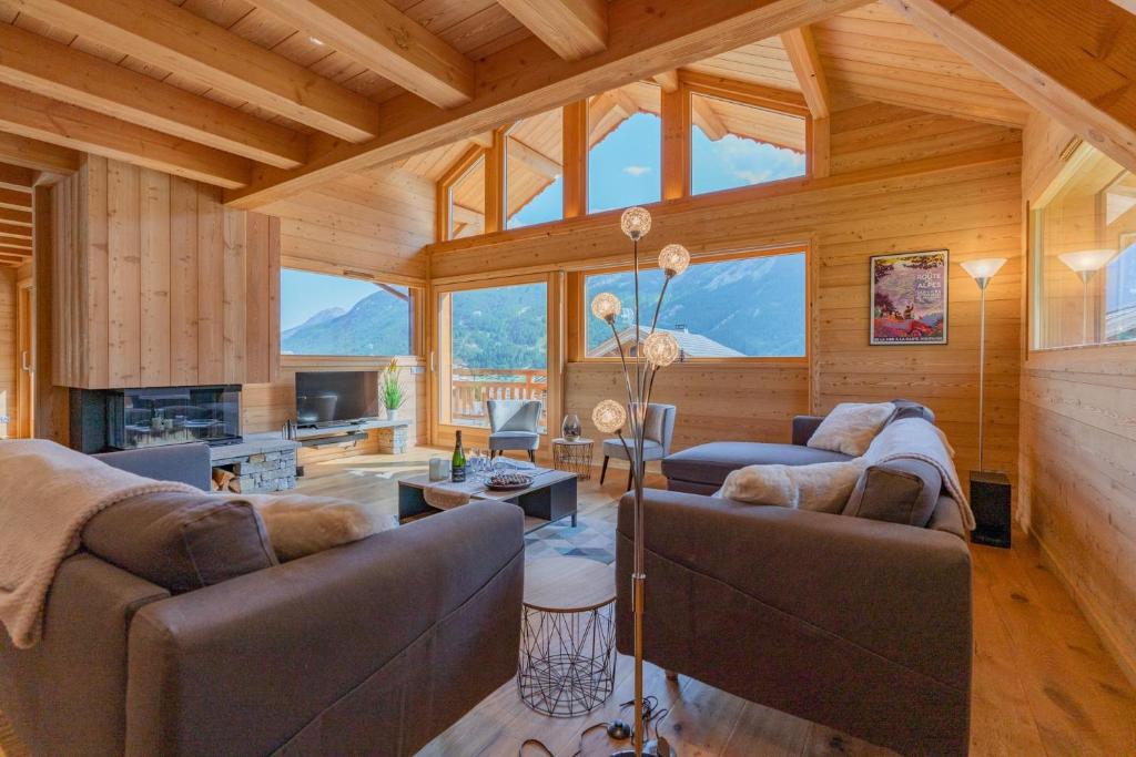 a living room with two couches and a fireplace at Aigle in Le Monêtier-les-Bains
