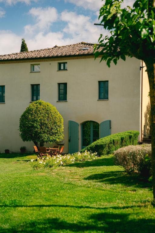 a house with a green door and a grass yard at Dimora DiVino in Palazzone