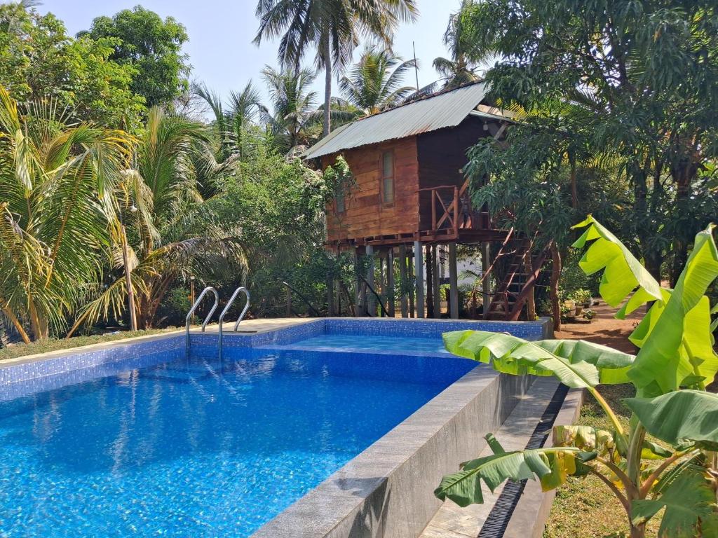 a swimming pool in front of a house at Lakeside Haven Resort in Habarana