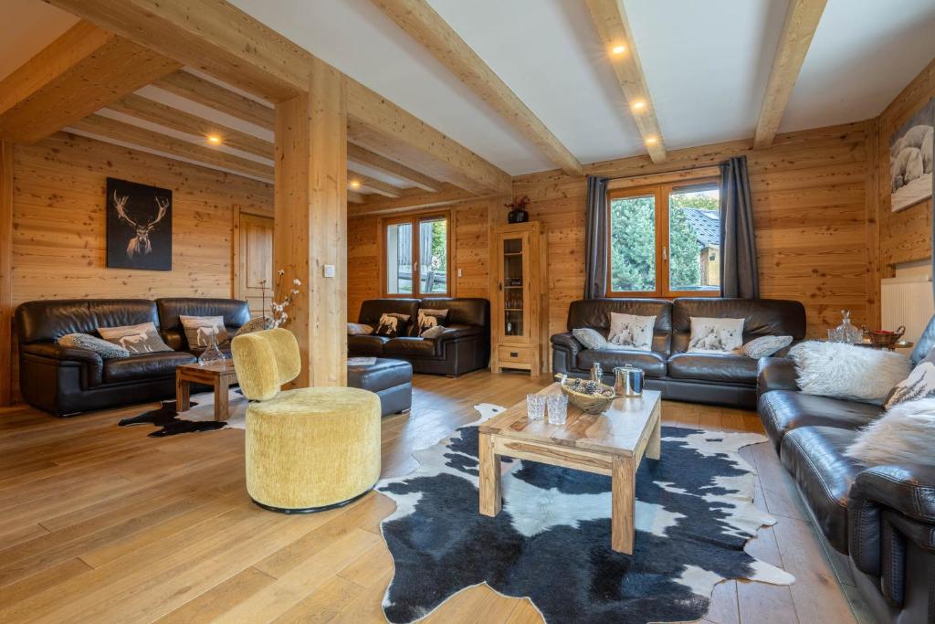 a living room with leather furniture and wooden walls at Le Stam in La Salle-les-Alpes