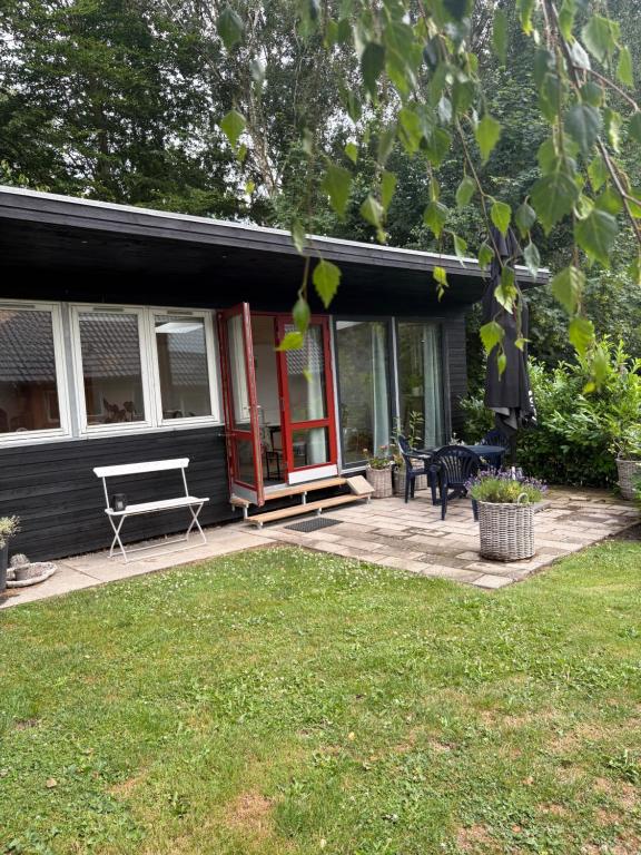 a house with a porch and a bench on a patio at Skuret Maribo in Maribo