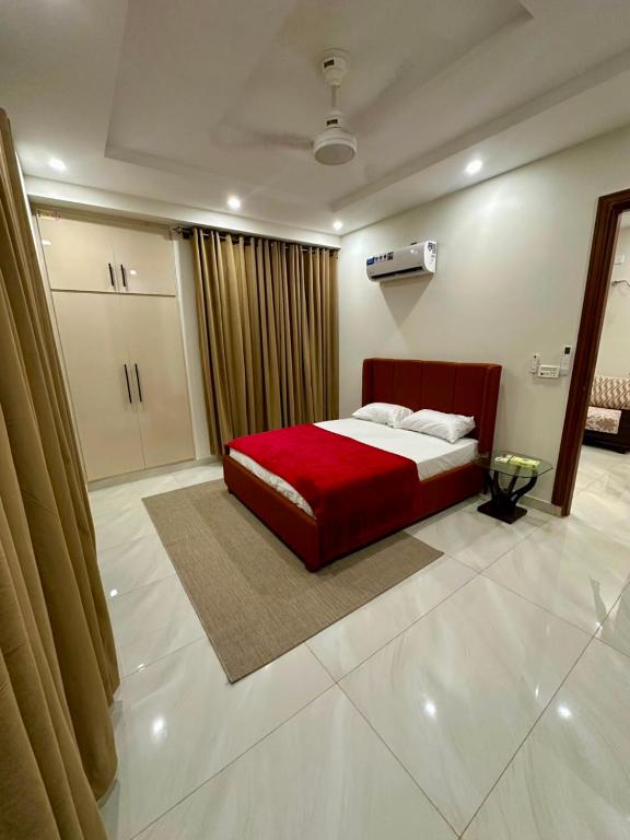 a bedroom with a bed with a red bedspread at Premium Pavilion in Islamabad
