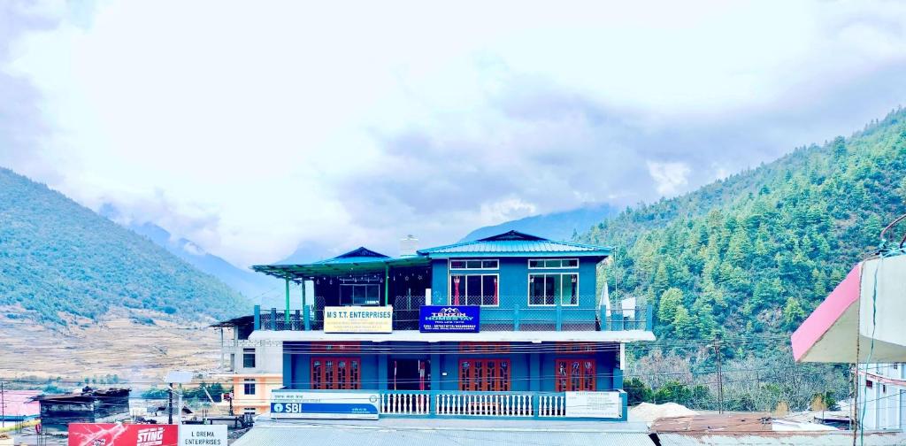 a blue building on top of a mountain at Tenzin Homestay in Dirang Dzong