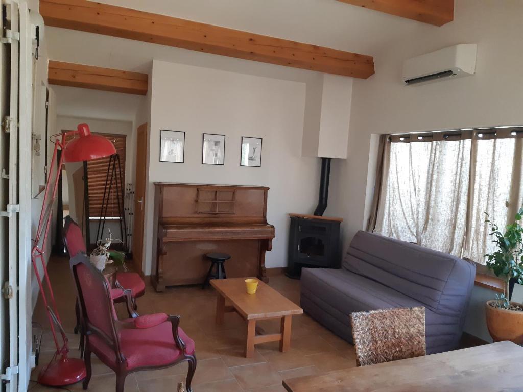 a living room with a couch and a piano at RDJ Proche mer "L'Oustaou Cabriole" in Saint-Cyr-sur-Mer