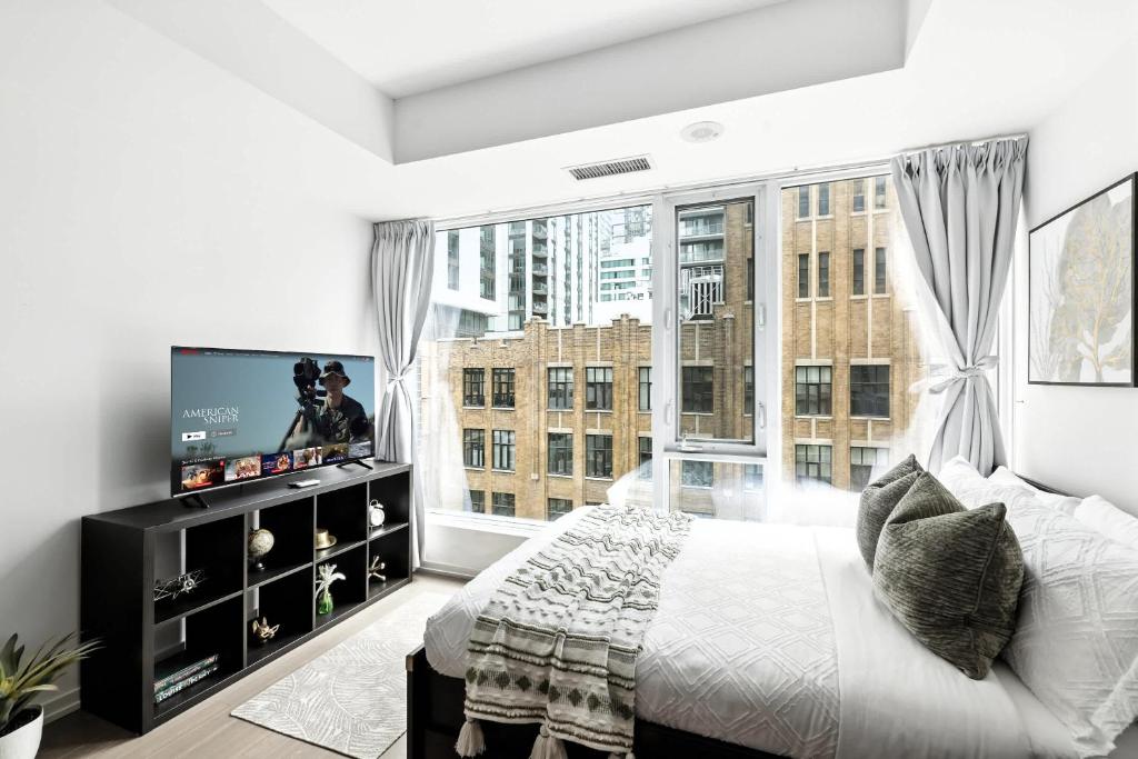 a bedroom with a bed and a large window at Entertainment District Gem Walk to CN Tower in Toronto
