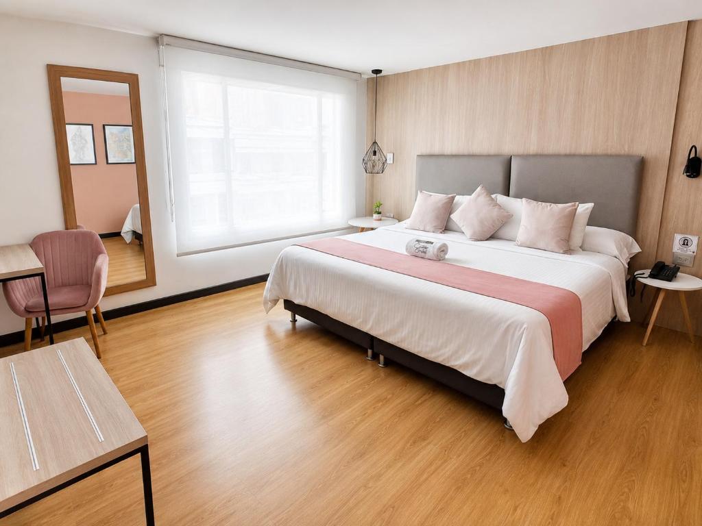 a bedroom with a large bed and a large window at HOTEL SANTORI in Pasto