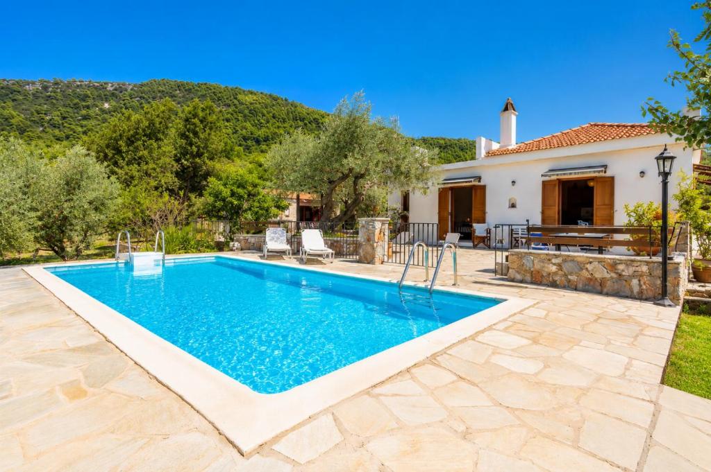 a swimming pool in a backyard with a house at Villa Ioanna in Skopelos Town