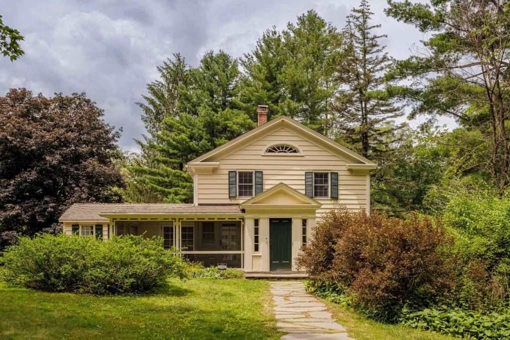 a small white house in the middle of a yard at The Whistling Oak - Pristine Pond Tranquility in Craryville
