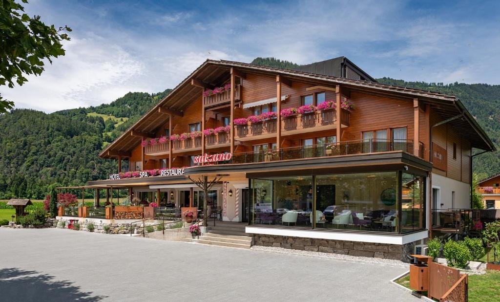a large wooden building with a lot of windows at SALZANO Hotel - Spa - Restaurant in Interlaken